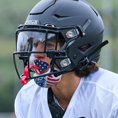 Lifestyle Image of Teen/Adult Tackle Football Player Wearing Showtime Chin Strap Cover (Stars & Stripes Design) - Angle View