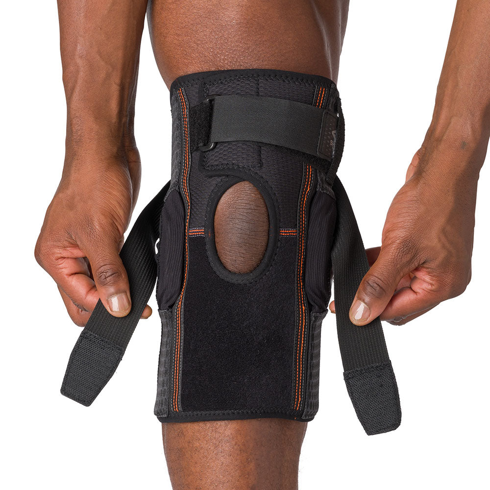 Shock Doctor Hyperlite Knee Brace with Heavy Duty Hinges - On-Body - Athlete using Adjustable Strap for Better Fit Over Patella