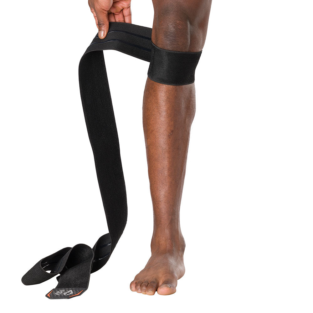 HyperWrap Multi-Use Compression Wrap by Shock Doctor shown in black, providing adjustable support for knee with wrap-around design. Model wrapping it around their patella.