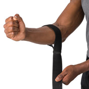 HyperWrap Multi-Use Compression Wrap by Shock Doctor shown in black, providing adjustable support for elbow with wrap-around design. Model wrapping it around their elbow.