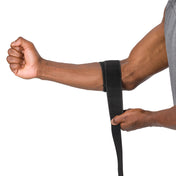 HyperWrap Multi-Use Compression Wrap by Shock Doctor shown in black, providing adjustable support for elbow with wrap-around design. Model wrapping it around their elbow.