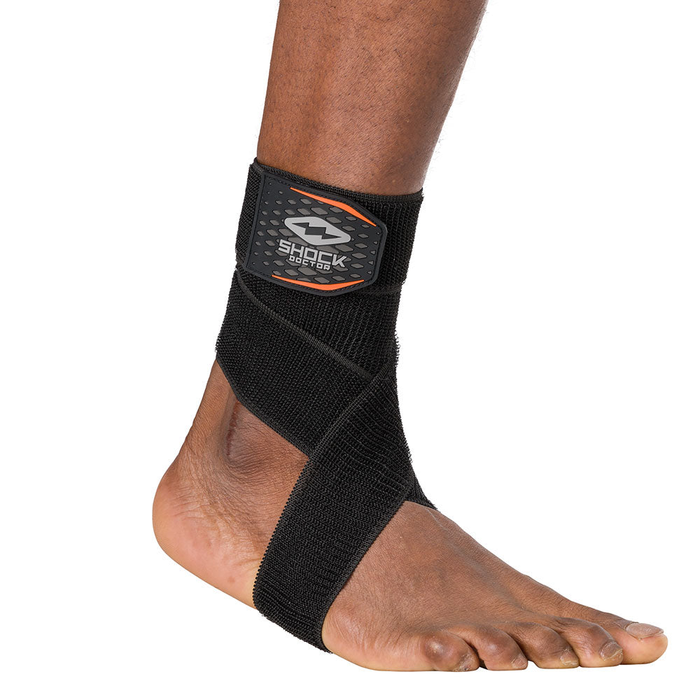 HyperWrap Multi-Use Compression Wrap by Shock Doctor shown in black, providing adjustable support for ankle with wrap-around design.