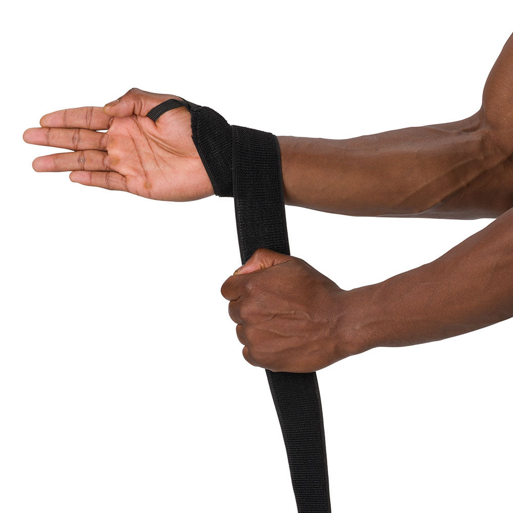 HyperWrap Multi-Use Compression Wrap by Shock Doctor shown in black, providing adjustable support for wrist with wrap-around design. Model wrapping it around their wrist.