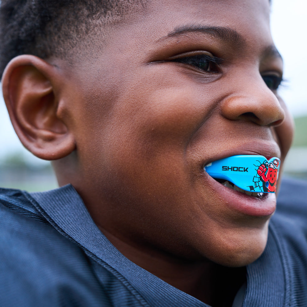 Youth Tackle Football Player Wearing Shock Doctor Kool Aid Gel Max Power Flavor Fusion Mouthguard - Detail View