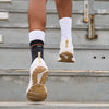 Detail View of Shock Doctor Compression Knit Ankle Sleeve with Gel Support - On Model - Mid Run on Bleachers in Stadium