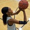 Female Basketball Athlete Shooting Ball While Wearing Shock Doctor Compression Knit Elbow Sleeve with Gel Support 