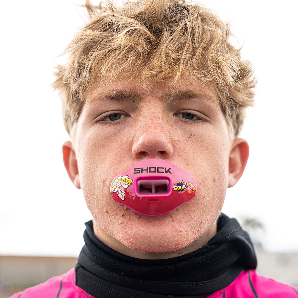 Lifestyle Image of Youth 7v7 Football Player Wearing Shock Doctor Warheads Sour Watermelon Max AirFlow Football Mouthguard